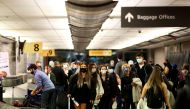 FILE PHOTO: Travelers wearing protective face masks to prevent the spread of the coronavirus disease (COVID-19) reclaim their luggage at the airport in Denver, Colorado, U.S., November 24, 2020. REUTERS/Kevin Mohatt/File Photo