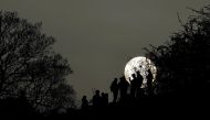 FILE PHOTO: People socialise in Primrose Hill park with the sun seen behind, as lockdown restrictions are eased in England, amid the spread of the coronavirus disease (COVID-19), in London, Britain, April 1, 2021. REUTERS/Toby Melville