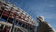 A person wearing a protective mask walks towards the coronavirus disease (COVID-19) vaccination centre situated at a temporary hospital organised at the National Stadium in Warsaw, Poland April 2, 2021. Reuters/Kacper Pempel