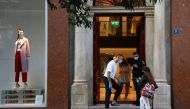 People wearing masks wait to enter a shop on the first day of the re-opening of retail stores, amid the coronavirus disease (COVID-19) pandemic, in Athens, Greece, April 5, 2021. REUTERS/Louiza Vradi