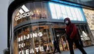 People walk past an Adidas store in a shopping district following an outbreak of the coronavirus disease (COVID-19) in Beijing, China, April 5, 2021. REUTERS/Thomas Peter