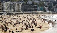 People enjoy the sun at La Concha beach after Spain introduced stricter mask laws during the coronavirus disease (COVID-19) outbreak, in San Sebastian, Spain March 31, 2021. REUTERS/Vincent West
