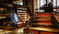 A woman uses a smartphone at Yeliseyevsky Store in central Moscow, Russia April 2, 2021. A historic grocery store in central Moscow is to close its doors after trading for more than a hundred years due to legal issues and a drop in tourism caused by the C
