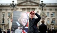 A man hold a poster depicting late Prince Philip outside Buckingham Palace after Britain's Prince Philip, husband of Queen Elizabeth, died at the age of 99, in London, Britain, April 10, 2021. REUTERS/Henry Nicholls