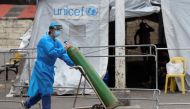 A health worker transports an oxygen tank at a coronavirus disease (COVID-19) facility at Santa Ana Hospital, in Manila, Philippines, April 9, 2021. REUTERS/Lisa Marie David