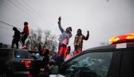 Demonstrators stand on a police vehicle during a protest after police allegedly shot and killed a man, in Brooklyn Center, Minnesota, U.S., April 11, 2021. REUTERS/Nick Pfosi