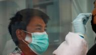 A healthcare worker performs a coronavirus disease (COVID-19) nasal swab test on a local resident, in Bangkok, Thailand, April 14, 2021. Reuters/Soe Zeya Tun