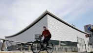 A man wearing a protective mask amid the coronavirus disease (COVID-19) outbreak, cycles past Ariake Arena in Tokyo, Japan, April 8, 2021. Picture taken on April 8, 2021. REUTERS/Kim Kyung-Hoon