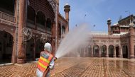 A worker sprays disinfectant to sanitize a mosque ahead of the holy fasting month of Ramadan, as the spread of coronavirus disease (COVID-19) continues, in Peshawar, Pakistan April 13, 2021. REUTERS/Fayaz Aziz 