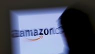 A zoomed illustration image of a man looking at a computer monitor showing the logo of Amazon is seen in Vienna November 26, 2012. REUTERS/Leonhard Foeger/File Photo