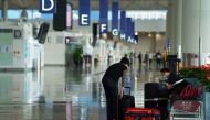 A woman, wearing a face mask following the coronavirus disease (COVID-19) outbreak, sorts luggage at Hong Kong International Airport in Hong Kong, China October 20, 2020. REUTERS/Lam Yik/File Photo

