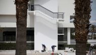 Workers wearing protective face masks put tiles on the pool area of Blue Sea Beach Resort, amid the coronavirus disease (COVID-19) pandemic, on the island of Rhodes, Greece, April 14, 2021. Picture taken April 14, 2021. REUTERS/Louiza Vradi