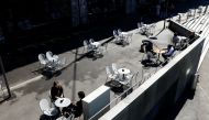 People sit on a terrace at Les Arches bar in the city centre, as coronavirus disease (COVID-19) lockdown restrictions ease, in Lausanne, Switzerland April 19, 2021. REUTERS/Denis Balibouse