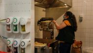 A woman prepares popcorn for takeaway on the first day of the opening of cinema theatres after a country lockdown, amid the coronavirus disease (COVID-19) pandemic, in Sintra, Portugal, April 19, 2021. REUTERS/Pedro Nunes