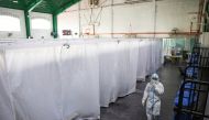 A health worker in personal protective equipment walks inside a covered court used as a quarantine facility for coronavirus disease (COVID-19) patients in Manila, Philippines, April 15, 2021. REUTERS/Eloisa Lopez