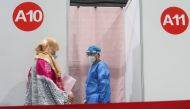 A woman enters a booth to get a coronavirus disease (COVID-19) vaccine at a vaccination center, during a government-organized visit, in Beijing, China, April 15, 2021. REUTERS/Thomas Peter
