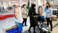 A shop assistant checks the negative COVID-19 test certificate as customers come to a store in the mall, as shops reopen after a lockdown, amid the coronavirus disease (COVID-19) pandemic in Trencin, Slovakia, April 19, 2021. REUTERS/Radovan Stoklasa/File
