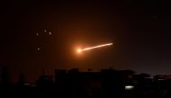 FILE PHOTO: A streak of light is seen in the night sky in the vicinity of the Syrian capital Damascus during what Syrian authorities said was an Israeli air strike, in this handout released by state news agency SANA on February 24, 2020. 