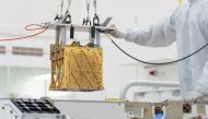 Technicians at NASA's Jet Propulsion Laboratory lower the Mars Oxygen In-Situ Resource Utilization Experiment (MOXIE) instrument into the belly of the Perseverance rover in an undated photograph in Pasadena, California, U.S. NASA/JPL-Caltech/Handout via R