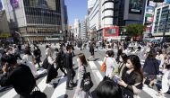 Passersby wearing protective face masks walk on Shibuya crossing amid the coronavirus disease (COVID-19) outbreak in Tokyo, Japan April 23, 2021, in this photo taken by Kyodo. 