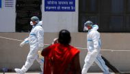 A health worker wearing personal protective equipment (PPE) carries an oxygen cylinder into the casualty ward at Guru Teg Bahadur Hospital, in New Delhi, India, April 24, 2021. REUTERS/Adnan Abidi