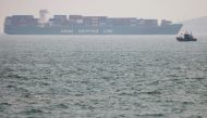 A fishing boat is seen near a China Shipping Container Lines (CSCL) vessel off the coast of Qingdao, Shandong province, China, following an oil spill in the Yellow Sea caused by a collision between tanker A Symphony and bulk vessel Sea Justice off Qingdao