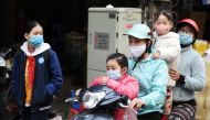 A family wears protective masks as they ride a motorbike in the street amid the coronavirus disease (COVID-19) outbreak in Hanoi, Vietnam, January 29, 2021. REUTERS/Thanh Hue/File Photo