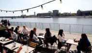 Guests enjoy the sunny weather as they sit in front of a restaurant after the Hungarian government allowed to reopen outdoor terraces, as the spread of the coronavirus disease (COVID-19) continues in Budapest, Hungary, April 24, 2021. REUTERS/Bernadett Sz