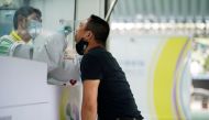 A healthcare worker takes a nasal swab sample from a person for a coronavirus disease (COVID-19) test, as the country deals with a fresh wave of infections after tackling earlier outbreaks, in Bangkok, Thailand April 16, 2021. REUTERS/Athit Perawongmetha/
