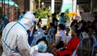 A healthcare worker takes a nasal swab sample from a person for a coronavirus disease (COVID-19) test, at a temple near Klong Toey slum community in Bangkok, Thailand, May 3, 2021. REUTERS/Juarawee Kittisilpa