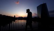 A man wearing a protective mask walks past the European Central Bank (ECB) during sunset as the spread of the coronavirus disease (COVID-19) continues in Frankfurt, Germany, April 18, 2021. REUTERS/Kai Pfaffenbach/File Photo