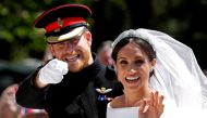 Britain’s Prince Harry gestures next to his wife Meghan as they ride a horse-drawn carriage after their wedding ceremony at St George’s Chapel in Windsor Castle in Windsor, Britain, May 19, 2018. REUTERS/Damir Sagolj/File Photo