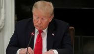 FILE PHOTO: U.S. President Donald Trump is seen tapping the screen on a mobile phone during a roundtable discussion on the reopening of small businesses in the State Dining Room at the White House in Washington, U.S., June 18, 2020. REUTERS/Leah Millis/Fi