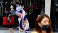FILE PHOTO: A woman in kimono clad and pedestrians wearing protective face masks, make their way at a shopping district on the first day of the country's third state of emergency, amid the coronavirus disease (COVID-19) outbreak, in Tokyo, Japan, April 25