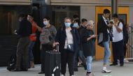 People, some wearing protective face masks, stand on a train platform at Central Station after new public health regulations were announced for greater Sydney, including compulsory mask-wearing on public transport, following the emergence of new cases of 