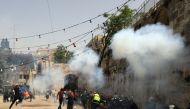 Palestinians run away as Israeli police fire a stun grenade during clashes at the compound that houses Al-Aqsa Mosque, known to Muslims as Noble Sanctuary and to Jews as Temple Mount, in Jerusalem's Old City, May 10, 2021. REUTERS/Ammar Awad