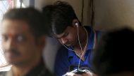 File photo: A man watches a video on his mobile phone as he commutes by a suburban train in Mumbai, India. Reuters/Shailesh Andrade/File Photo