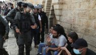 A Palestinian man and an Israeli border policeman gesture amid tension at Damascus Gate just outside Jerusalem's Old City on May 10, 2021. (REUTERS/Ronen Zvulun)