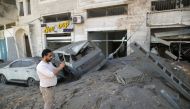 A Palestinian man takes pictures of the damage in the aftermath of Israeli air strikes, amid a flare-up of Israeli-Palestinian violence, in Gaza City May 12, 2021. REUTERS/Suhaib Salem