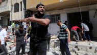 A Palestinian man reacts at the scene where a house was hit by an Israeli air strike, amid a flare-up of Israeli-Palestinian violence, in the southern Gaza Strip May 12, 2021. REUTERS/Ibraheem Abu Mustafa