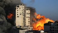 Smoke and flames rise from a tower building as it is destroyed by Israeli air strikes amid a flare-up of Israeli-Palestinian violence, in Gaza City May 12, 2021. REUTERS/Ibraheem Abu Mustafa