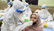 A medical worker collects a swab sample from a woman to be tested for the coronavirus disease (COVID-19) in Kuala Lumpur, Malaysia, May 11, 2021. REUTERS/Lim Huey Teng/File Photo