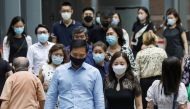 Office workers wearing masks cross a street during lunch hour, amid the coronavirus disease (COVID-19) outbreak, in Singapore May 12, 2021. REUTERS/Dawn Chua/File Photo