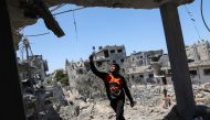 A Palestinian man gestures at the site of destroyed houses in the aftermath of Israeli air and artillery strikes as cross-border violence between the Israeli military and Palestinian militants continues, in the northern Gaza Strip May 14, 2021. REUTERS/Mo