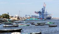 FILE PHOTO: Boats are seen as container ship is beside cranes at the Suez canal near Ismailia port city, northeast of Cairo, Egypt March 5, 2021. REUTERS/Mohamed Abd El Ghany