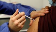 A medical worker administers a dose of the 