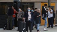 File photo: People, some wearing protective face masks, stand on a train platform at Central Station after new public health regulations were announced for greater Sydney, including compulsory mask-wearing on public transport, following the emergence of n