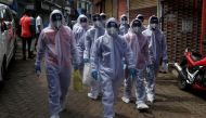 Healthcare workers wearing personal protective equipment (PPE) walk towards different localities before the start of a check-up camp for the coronavirus disease (COVID-19) in Mumbai, India June 27, 2020. REUTERS/Francis Mascarenhas
