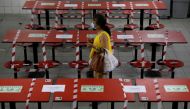 A woman walks between rows of taped up tables at a food centre as dining-in is restricted to curb the coronavirus disease (COVID-19) outbreak in Singapore May 17, 2021. REUTERS/Edgar Su
