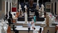 FILE PHOTO: Visitors, wearing protective face masks, look at artworks during a visit at the Musee d'Orsay, the former Gare d'Orsay train station, in Paris as the museum re-opens doors to the public following the coronavirus disease (COVID-19) outbreak in 